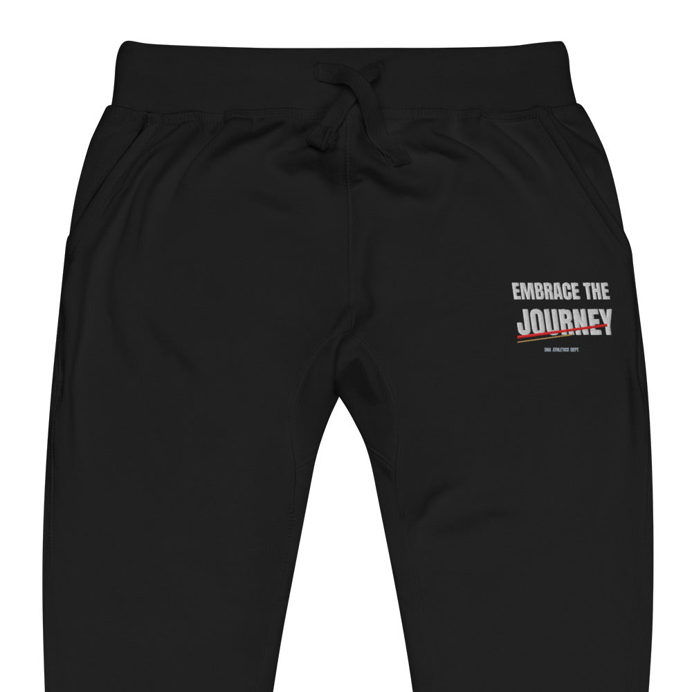 Embrace the Journey Joggers in Black — close-up of the embroidered Embrace the Journey design at the left thigh