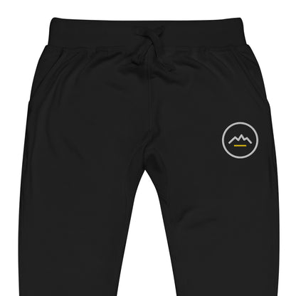 Summit Emblem Joggers in Black — close-up of the embroidered Summit emblem at the left thigh