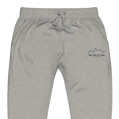 One Step at a Time Joggers in Carbon Grey — close-up of the embroidered One Step at a Time logo at the left thigh