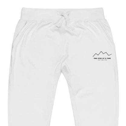 One Step at a Time Joggers in White — close-up of the embroidered One Step at a Time logo at the left thigh